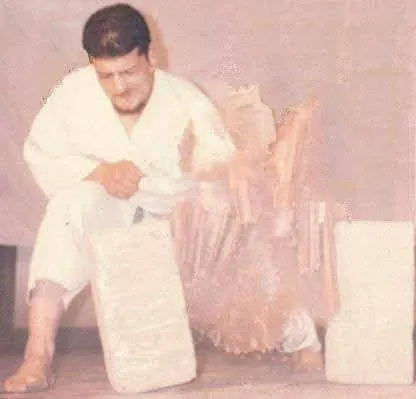 Black belt breaking a stack of boards between two bricks