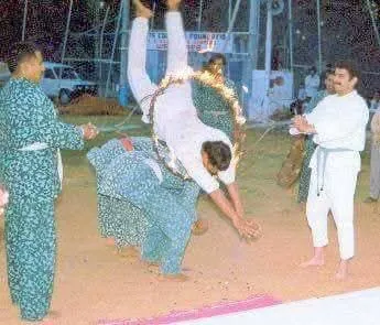 Student diving through a ring of fire at an outdoor demonstration